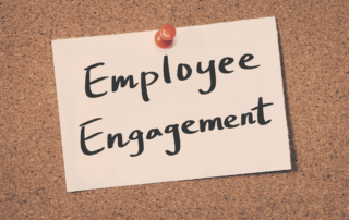 A small note that says “Employee Engagement” is tacked to a corkboard, representing employee engagement and retention.