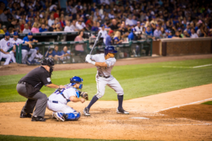 A shot of a professional baseball player, ready at bat, during an evening game.